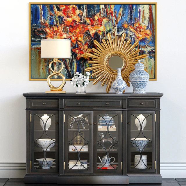 A chest of drawers with a collection of decor, a lamp and a set of sculptures — Descargar